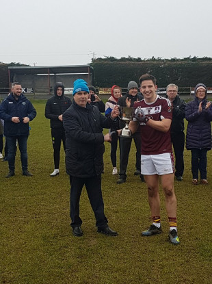 Gerry Tully presents the Corn Daithi Billings to NUIG captain Evan O'Brien.
