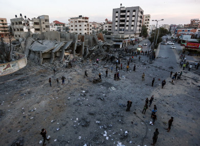 Palestinians inspect the remains of a building that was destroyed during Israeli airstrikes.