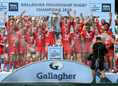 Saracens players lift the trophy following victory.