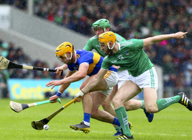 Tipperary's Ronan Maher is tackled by Limerick's Seamus Flanagan and Shane Dowling.