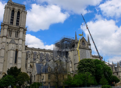 A statue is removed from Notre-Dame de Paris after April's fire.