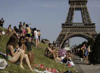 People enjoy the sun on the Trocadero gardens near the Eiffel Tower in Paris, Friday,