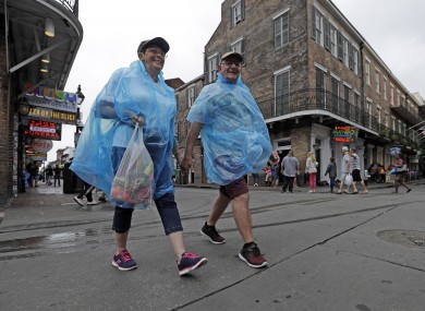 Alan and Dot Richardson wear ponchos as they walk along Bourbon Street in the French Quarter in New Orleans.