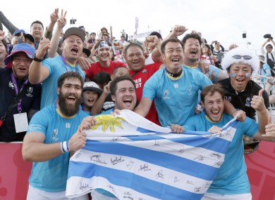 Uruguay players celebrate with supporters in Kamaishi.