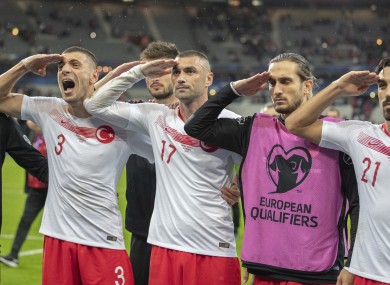 Turkey players celebrate with a military salute.