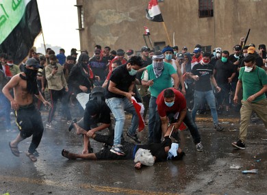 An injured protestor is rushed to a hospital during a demonstration in central Baghdad.