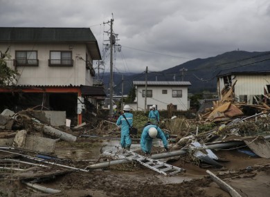 Electricity workers survey damages in a neighborhood devastated by Typhoon Hagibis