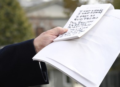 Trump holds handwritten notes as he makes remarks to the press about the impeachment inquiry. The notes read: