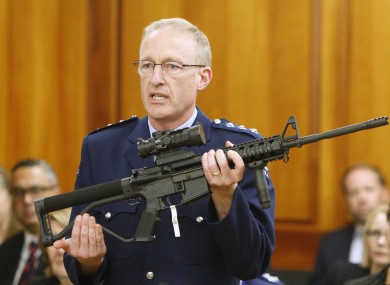 Police acting superintendent Mike McIlraith shows New Zealand lawmakers an AR-15 style rifle similar to one of the weapons a gunman used.