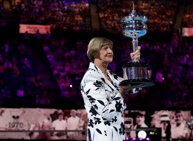 Margaret Court is presented with a replica trophy during a ceremony to mark the 50th anniversary of her Grand Slam win.