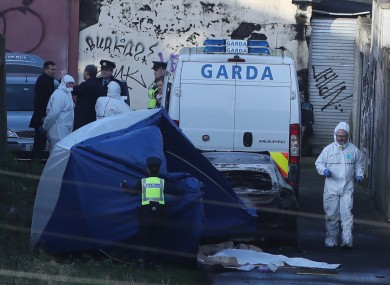 A tent is placed in front of the burnt out car in Ballybough, where remains were discovered yesterday.