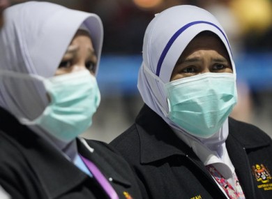 Health officials wear face masks at Kuala Lumpur International Airport in Malaysia.