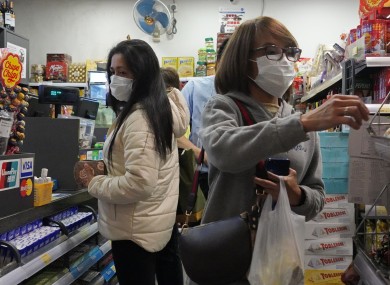 People wear protective face masks as they make purchases from a convenience store in Hong Kong.