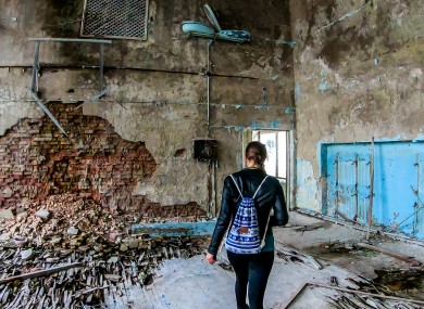 A woman walks in an abandoned school gym in Pripyat.