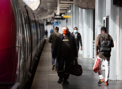People wearing face masks wait for a train at Gare du Nord during the lockdown in Paris