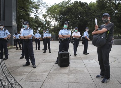 A man stands next to police as people gather to mourn those killed in the 1989 Tiananmen crackdown at victory park in Causeway Bay.