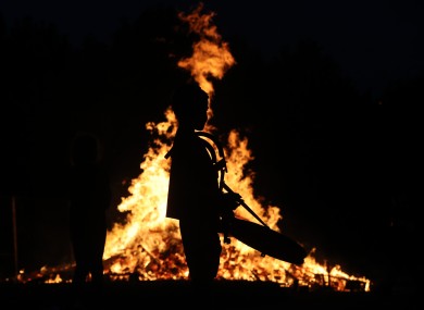 A young boy plays drums by a bonfire on Belfast's Shankill Road as bonfires were lit at midnight.