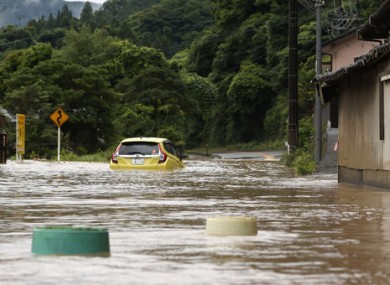 A car is stuck in a flooded road by heavy rain in Yatsushiro, Kumamoto prefecture, southwestern Japan.
