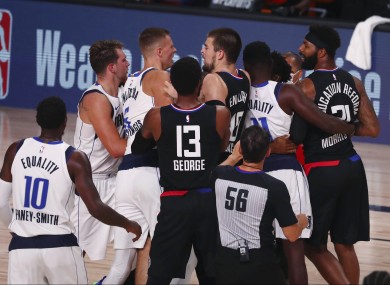 Officials separate the Dallas Mavericks and LA Clippers after the teams get into a scuffle.