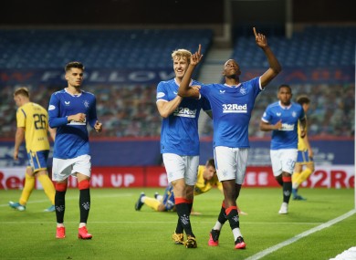 Joe Aribo celebrates, chased by team mate Filip Helander, after scoring to give Rangers a 3-0 lead last night.