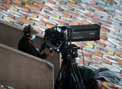 A TV camera operator wearing PPE during a Premier League match at Molineux.