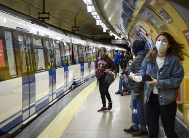 Passengers wearing face masks wait for the metro at the station in Madrid.