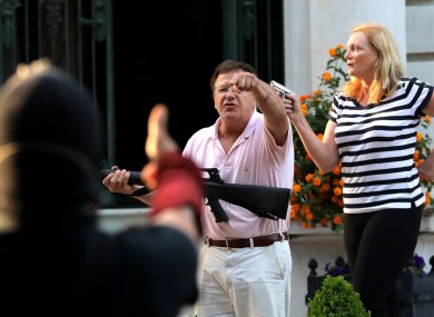 Armed homeowners Mark T. and Patricia N. McCloskey stand in front their house as they confront protesters marching to St. Louis Mayor Lyda Krewson's house on June 28, 2020.
