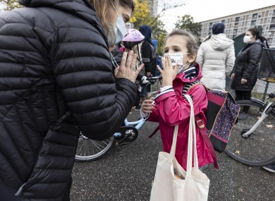 A mother and her daughter wave goodbye as school resumes with new sanitary precautions during the lockdown in Strasbourg, Eastern France which went into shutdown mode on Friday.