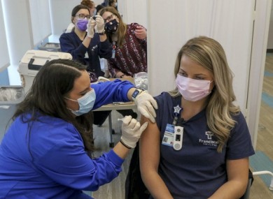 Certified nurse assistant Kisa Kniola, left, gives a Covid-19 vaccination to registered nurse Lindsay Kreighbaum at Franciscan Health in Michigan City, Indiana.