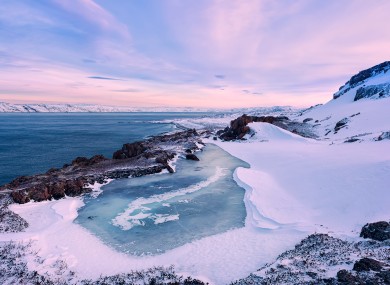 A small frozen lake and the Barents Sea coastline, Russia