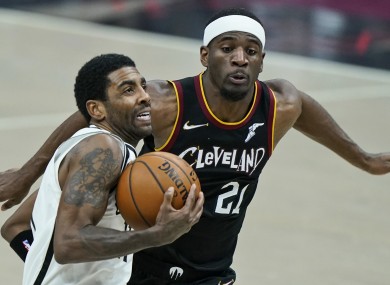 The Nets' Irving (front) drives to the basket.