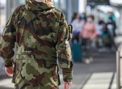 A member of the Defence Forces prepares to escort passengers to mandatory quarantine from Dublin Airport.