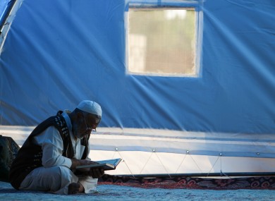 A man in a Syrian refugee camp reading.