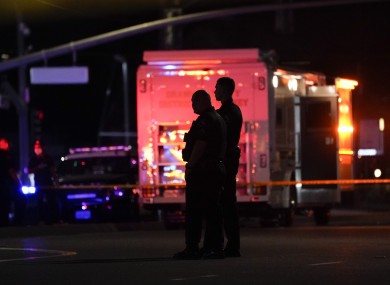 Two police officers stand outside the office building where the deadly shooting occurred.