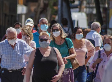 Image of people wearing face coverings outdoors..