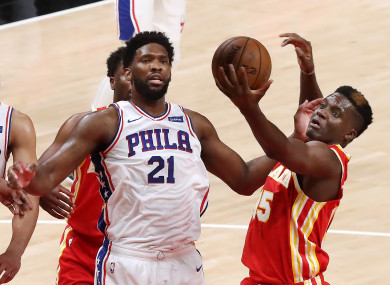 The Atlanta Hawks' Clint Capela, right, grabs a defensive rebound away from the Philadelphia 76ers' Joel Embiid.