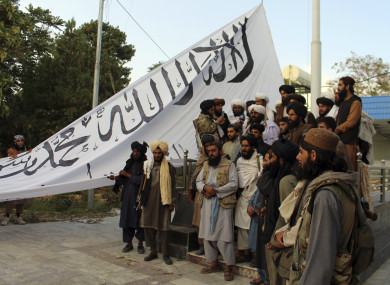 Taliban fighters raising their flag at the Ghazni provincial governor's house in southeastern Afghanistan yesterday.