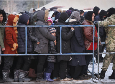 People queue to get hot food in the logistics centre of the checkpoint