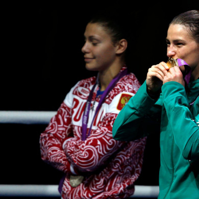 Sofya Ochigava looks on as Katie Taylor kisses her Olympic gold medal at London 2012.