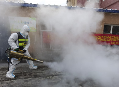 A volunteer disinfects the area as it snows during the lockdown in Changchun in northeast China's Jilin province