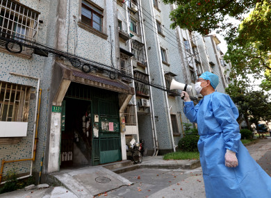 A volunteer broadcasting tips to residents in Baoshan District of Shanghai, east China yesterday.
