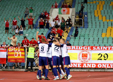 St. Patrick's Athletic's Serge Atakayi celebrates scoring the late goal to win the game with teammates in front of their travelling fans.